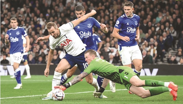 Tottenham Hotspuru2019s Harry Kane (centre) is tackled by Evertonu2019s goalkeeper Jordan Pickford resulting in a penalty during the Premier League match at Tottenham Hotspur Stadium in London yesterday. (AFP)