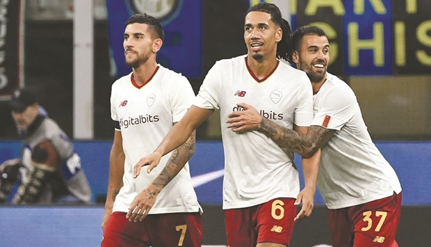AS Romau2019s Chris Smalling (centre) celebrates with teammates Lorenzo Pellegrini (left) and Leonardo Spinazzola after scoring during the Serie A match against Inter Milan yesterday. (AFP)