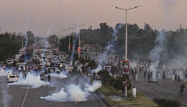 Police use tear gas to disperse Pakistan Tehreek-e-Insaf (PTI) protesters during a demonstration in Islamabad against the decision to disqualify former prime minister Imran Khan from running for political office.