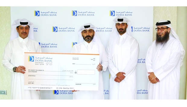 Ahmmed Omar AlSherawi, director of the Customer Service Department at QC, received the cheque from Ahmad Ali al-Hanzab, head of Administration and Properties at Doha Bank.
