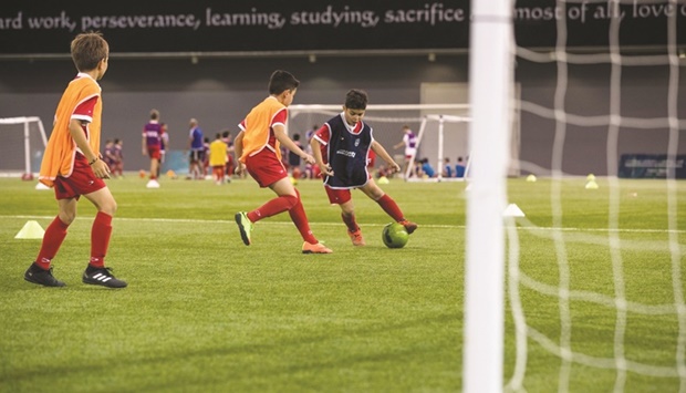 Young children in action during a match hosted by Qatar Community Football League.