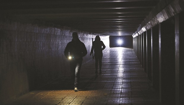 People use flashlights as they walk through an unlit underpass in the centre of Kyiv amid the Russian invasion of Ukraine. Due to the Russian shelling of the energy infrastructures of Ukraine, which occurred at night, energy supply is significantly limited in Kyiv, Zhytomyr, Cherkasy and Chernihiv regions.
