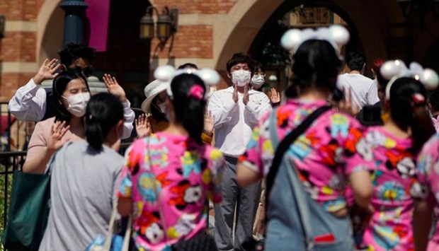 Staff members wearing face masks welcome visitors at the Shanghai Disney Resort, as the Shanghai Disneyland theme park reopens after being shut for the coronavirus disease (Covid-19) outbreak, in Shanghai, China June 30, 2022.