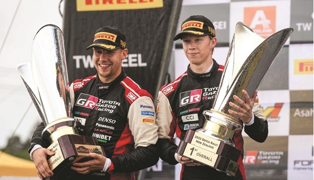 Toyota WRT driver Kalle Rovanpera (right) and Jonne Halttunen of Finland celebrate with the trophies after the winning the 2022 World Rally Championship title on the outskirts of Auckland. (AFP)