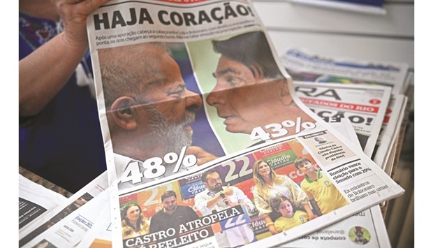 A vendor holds up the front page of one of Brazilu2019s national newspapers the day after the presidential elections.