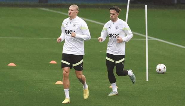 Manchester Cityu2019s Erling Haaland (left) and Jack Grealish during a training session in Manchester yesterday, ahead of their Champions League match against FC Copenhagen. (Reuters)