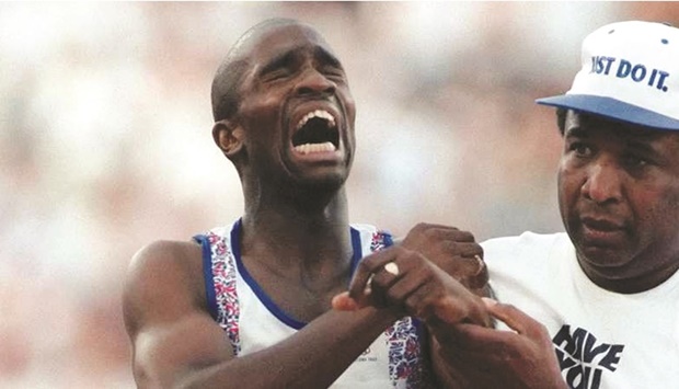 Derek Redmond is helped by his father, Jim, after suffering an  injury during a second round heat of the 400m at the 1992  Barcelona Olympics. (Pascal Pavani/AFP)