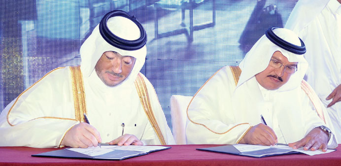 Al-Kaabi (left) and al-Ageel sign the memorandum of understanding.