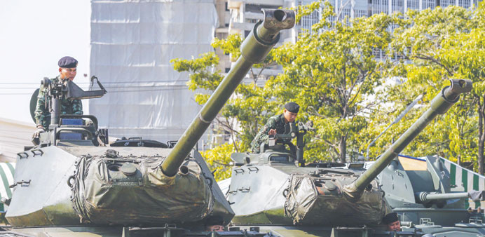 Thai soldiers sit on top of tanks at the Army base in central Bangkok yesterday.
