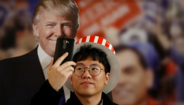 A man takes a selfie with a cut-out of Donald Trump during a US Election Watch event hosted by the US Embassy at a hotel in Seoul, South Korea
