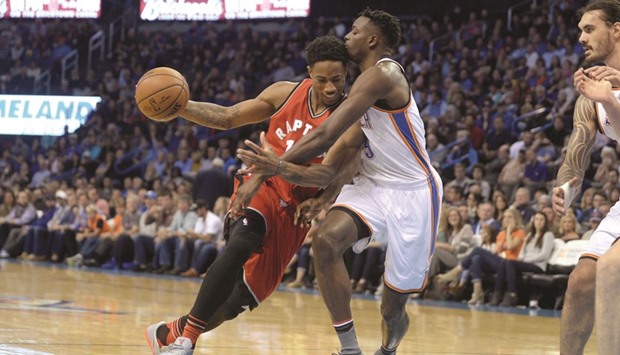 Toronto Raptors guard DeMar DeRozan (left) drives to the basket in front of Oklahoma City Thunder forward Jerami Grant (centre) during their NBA game in Oklahoma City on Wednesday. (USA TODAY Sports)