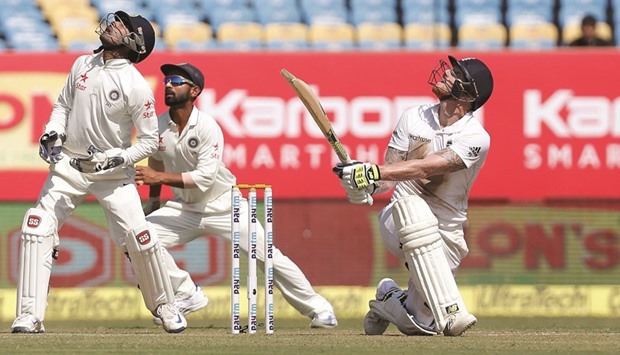Englandu2019s Ben Stokes plays a shot as Indiau2019s wicketkeeper Wriddhiman Saha (left) and Ajinkya Rahane (centre) look on during the first Test in Rajkot, India, yesterday. (AFP)
