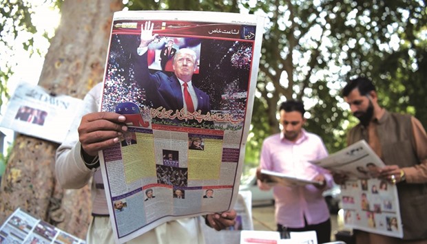 Pakistani residents read newspapers with coverage of Donald Trumpu2019s victory in the US presidential election, in Islamabad yesterday.