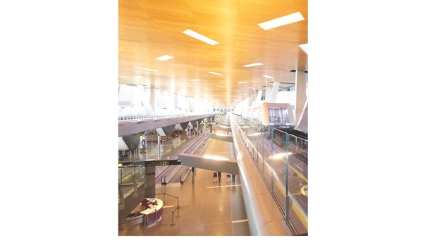 One of the passenger trains, right,  traverses the stretch of the Hamad International Airport passenger terminal.
