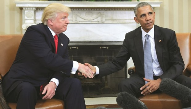 Barack Obama and Donald Trump shake hands during a transition planning meeting in the Oval Office at the White House yesterday.