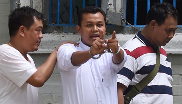 Wai Phyo (C), chief editor of the Eleven Media Group, is seen in handcuffs