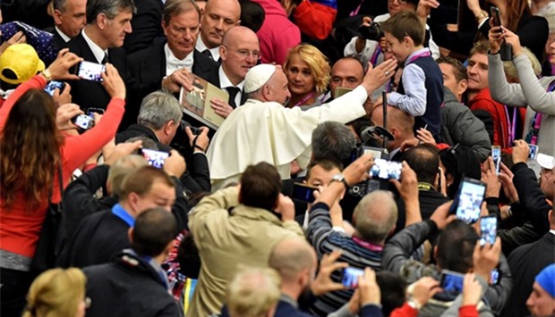 Pope Francis caresses a child's face during an audience with homeless and socially excluded people