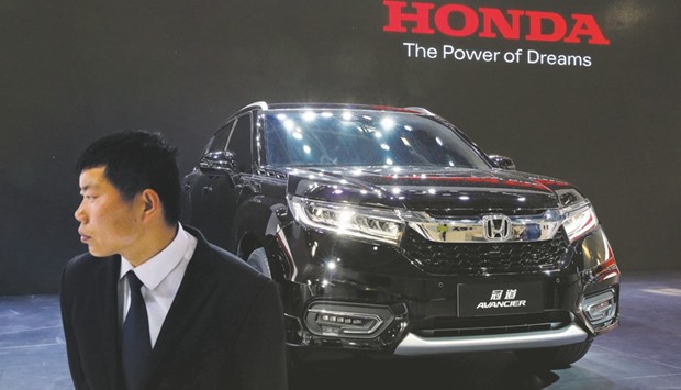 A security agent guards a Honda Avancier SUV at a showroom in Tokyo. The Japanese automaker said it will begin producing from early next year the Acura MDX SUV at its plant in East Liberty, Ohio.