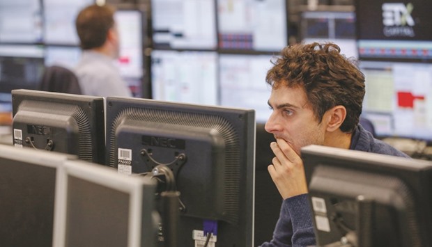 A trader looks at financial data on computer screens at the London Stock Exchange. The FTSE 100 bore the brunt of a rise in sterling above $1.26 and fell 1.4% at 6,730.43 points yesterday.