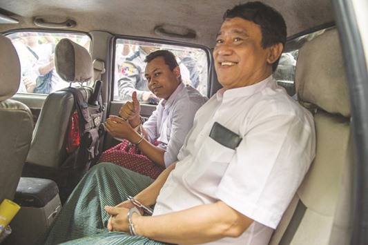 Than Htut Aung (right), chief executive of the Eleven Media Group, and chief editor Wai Phyo are seen in handcuffs in a police vehicle after appearing in court in Yangon.