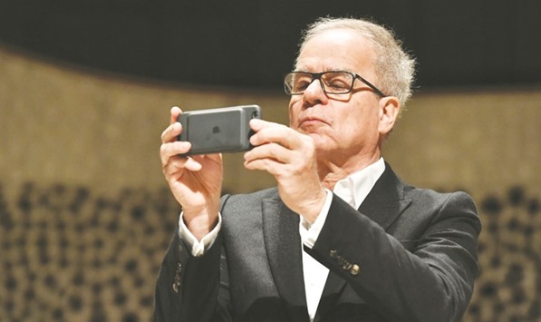 Architect Pierre de Meuron using his phone as he takes part in a press conference in the main concert hall of the just completed building of the Elbphilharmonie concert hall in Hamburg.