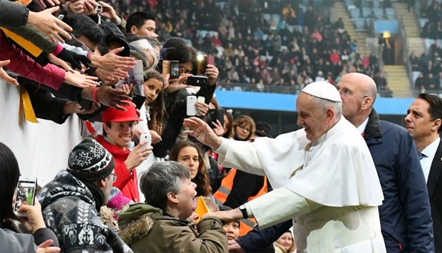 Pope Francis (C) shakes hands with wellwishers as he arrives at the Swedenbank Stadion
