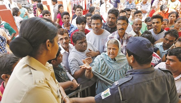 People argue with a police officer after they were stopped from entering a bank in Mumbai yesterday. Anger intensified across the country as banks struggled to dispense cash following the governmentu2019s decision to withdraw large denomination notes.