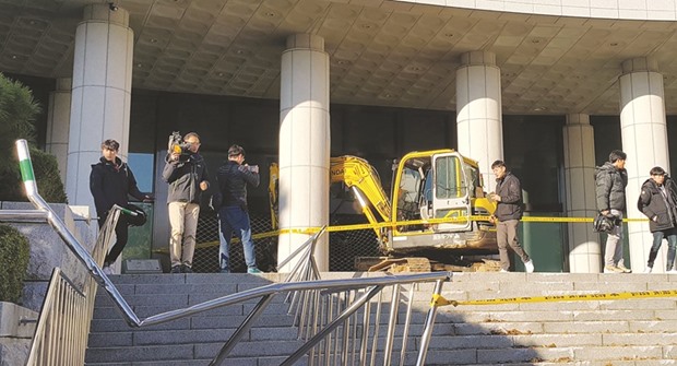 Cameramen surround the excavator after its driver attempted to ram the Central District Prosecutoru2019s Office in Seoul.