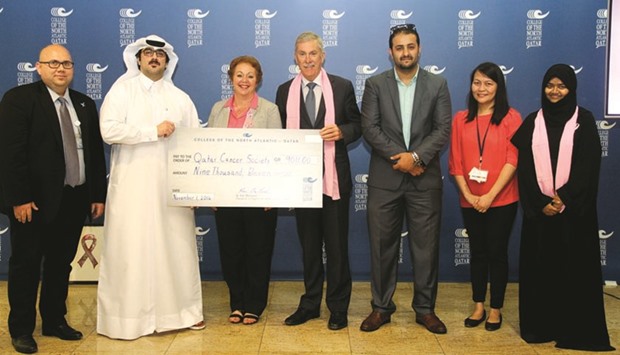 CNA-Q officials hand over the money raised for the Qatar Cancer Society through donations and raffle draws.
