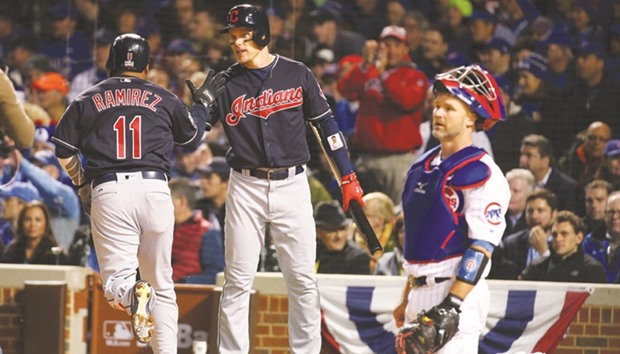 Cleveland Indians right fielder Brandon Guyer (centre) congratulates third baseman Jose Ramirez (11) for hitting a solo home run as Chicago Cubs catcher David Ross (right) looks on during Sunday's Game 5 of the 2016 World Series. (Jerry Lai-USA TODAY Sports)