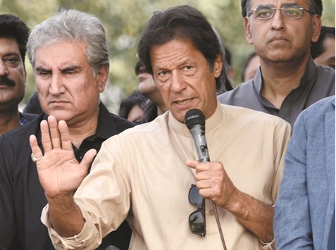 Pakistani opposition leader Imran Khan (C) talks to media outside his house in Islamabad yesterday.