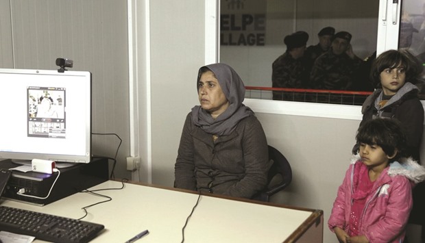 A refugee and her children are registered at the migrant registration centre on the Greek island of Chios.