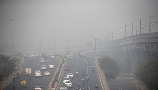Traffic drives through smog in Delhi