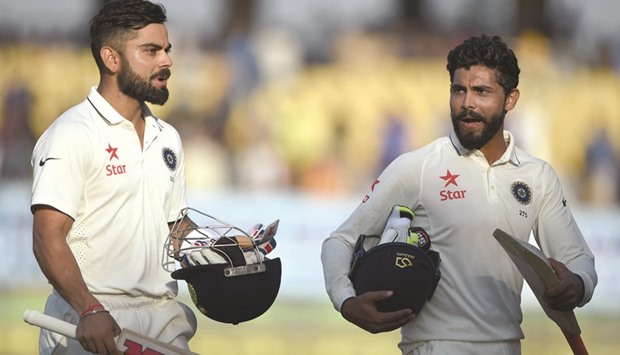 Indian captain Virat Kohli (left) and Ravindra Jadeja walk back at the end of play on the fifth day of the first Test against England, at the Saurashtra Cricket Association stadium in Rajkot yesterday. (AFP)