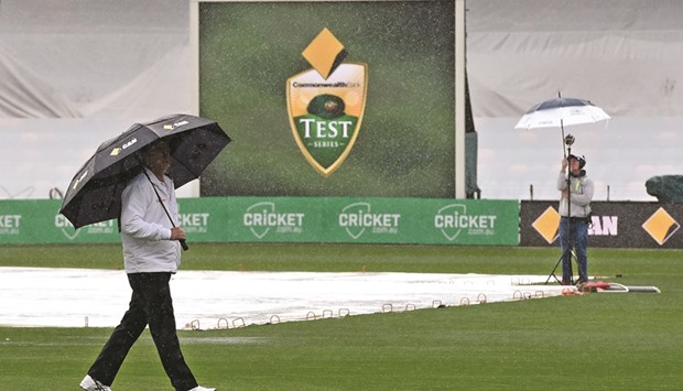 An umpire inspects the outfield as the second dayu2019s play of the second Test between Australia and South Africa was washed off due to rain in Hobart yesterday. (AFP)