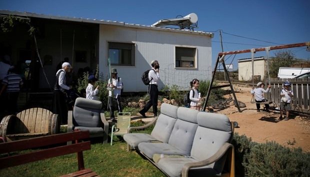 Visitors walk in a yard near a home in the Jewish settler outpost of Amona in the West Bank, during an event organised to show support for Amona which was built without Israeli state authorisation and which Israel's high court ruled must be evacuated and demolished by the end of the year as it is built on privately-owned Palestinian land. October 20, 2016, file picture.  Reuters