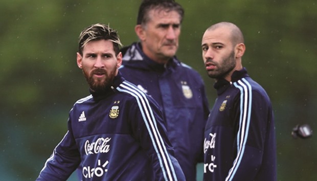 Argentinau2019s players Lionel Messi (L) and Javier Mascherano (R) walk by head coach Edgardo Bauza during training.