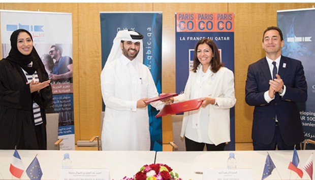 Al-Khalifa and Hidalgo exchange documents after signing the MoU as al-Mudahka and Chevallier look on.