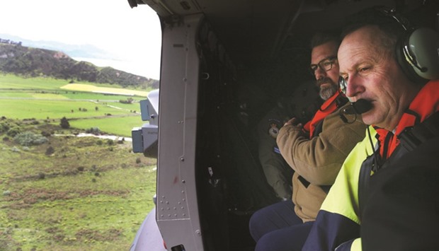 Prime Minister Key (right) inspecting earthquake damage near Kaikoura from a helicopter.