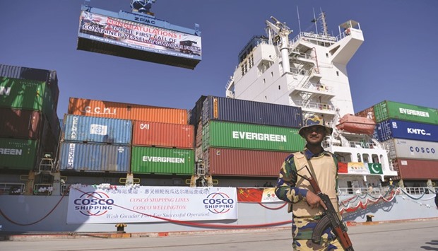 A Pakistani Naval personnel stands guard beside a ship carrying containers during the opening of a trade project in Gwadar port, some 700km west of Karachi on Sunday. Pakistanu2019s Prime Minister Nawaz Sharif on Sunday opened a trade route linking the southwestern post of Gwadar to the Chinese city of Kashgar as part of a joint multi-billion-dollar project to jumpstart economic growth in the South Asian country.