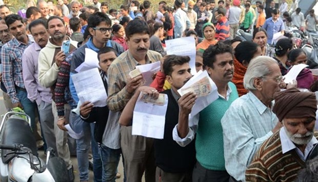 Indians queue outside a bank as they wait to deposit and exchange 500 and 1000 rupee notes in Amritsar.