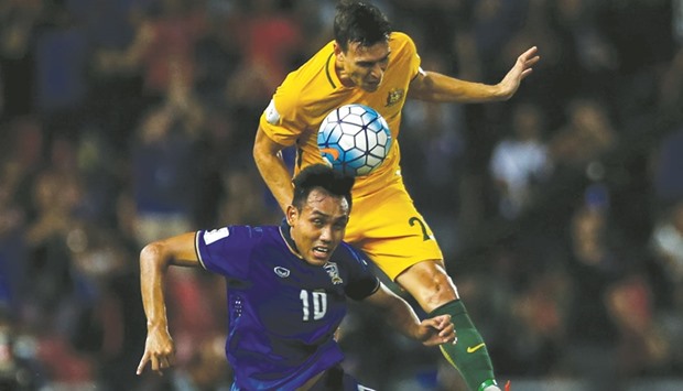 Thailandu2019s Teerasil Dangda is challenged by Australiau2019s Milos Degenek in Bangkok yesterday.