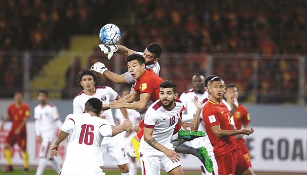 Qatar goalkeeper Saad al-Sheeb fends off a China attack in Kunming yesterday.