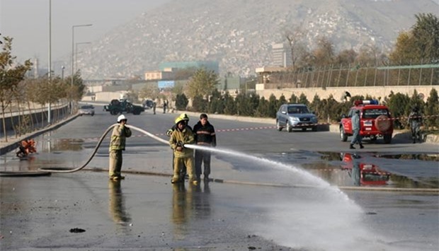 Afghan firefighters wash the road at the site of a suicide bombing in Kabul on Wednesday.
