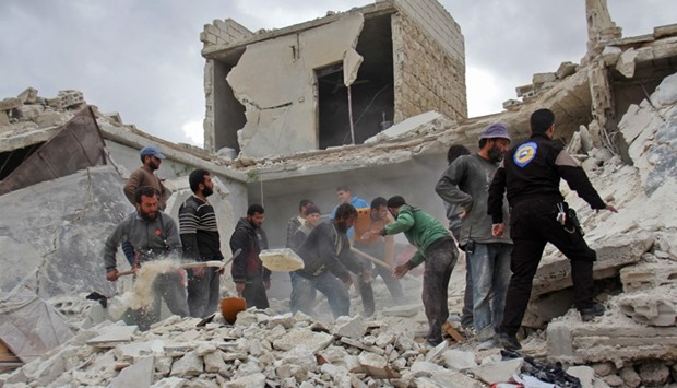 Rescuers and civilians inspect a destroyed building in the Syrian village of Kfar Jales, on the outskirts of Idlib, following air strikes by Syrian and Russian warplanes. AFP