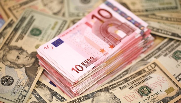 A stack of euro banknotes seen on a pile of US dollar bills in an arranged photograph inside a Travelex store in London. Traders see about a 45% chance the European currency will sink to $1 by the end of 2017, about double the probability assigned a week ago, data compiled by Bloomberg show.