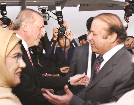 Prime Minister Nawaz Sharif greets Turkish President Recep Tayyip Erdogan upon his arrival at the military airbase in Islamabad.