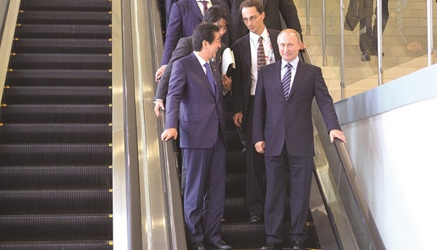 Russian President Vladimir Putin (right) and Japanese Prime Minister Shinzo Abe ride down an escalator during their meeting on the sidelines of Eastern Economic Forum in Vladivostok, Russia (file). Thirty joint economic projects due to be approved by the two leaders at a summit in Japan next month are a u2018win-win situation for Japan, even on their own,u2019 Japanu2019s minister for economic cooperation with Russia Hiroshige Seko said.