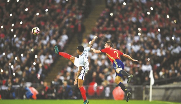 Englandu2019s defender Nathaniel Clyne (L) vies in the air with Spainu2019s defender Cesar Azpilicueta during the friendly match.