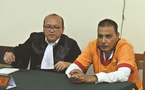 American Kamran Malik (right), who is also known as Phillip Russel, sits in a courtroom beside his legal counsel in Semarang, Central Java, Indonesia, yesterday.